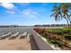 Charming patio with lounge chairs, vibrant flowers, and peaceful waterfront views at 9525 Blind Pass Rd # 301, St Pete Beach, FL 33706