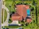 Aerial view showcasing the home's layout, pool, and landscaping, with a brick roof and well-maintained grounds at 1008 Royal Birkdale Dr, Tarpon Springs, FL 34688