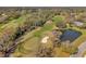 Aerial view of lush golf course, showcasing water features, greens, and scenic landscaping, offering a tranquil setting at 1008 Royal Birkdale Dr, Tarpon Springs, FL 34688
