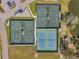 Aerial view of tennis courts near a parking lot and lakeside, showcasing the recreational amenities of the community at 1008 Royal Birkdale Dr, Tarpon Springs, FL 34688