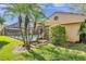 Backyard view of the screened-in pool, palm trees, and lush greenery providing privacy at 1008 Royal Birkdale Dr, Tarpon Springs, FL 34688