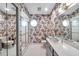 Retro floral bathroom with tiled floor, walk-in shower, and large vanity mirror at 1008 Royal Birkdale Dr, Tarpon Springs, FL 34688