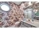 Elegant bathroom with unique floral wallpaper, vanity, and a glass-enclosed shower, providing a refreshing space at 1008 Royal Birkdale Dr, Tarpon Springs, FL 34688