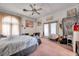 Spacious bedroom with a bed, seating area, art, and carpet, creating a comfortable, personalized living space at 1008 Royal Birkdale Dr, Tarpon Springs, FL 34688