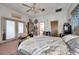 Bedroom featuring a bed with white comforter, ceiling fan, and access to a balcony through white-framed doors at 1008 Royal Birkdale Dr, Tarpon Springs, FL 34688