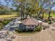 Aerial shot of the entry gate featuring stone pillars and a well-manicured landscape at 1008 Royal Birkdale Dr, Tarpon Springs, FL 34688