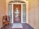 Inviting front door with glass brick sidelights, featuring an arched window above and a decorative carved wooden door at 1008 Royal Birkdale Dr, Tarpon Springs, FL 34688
