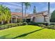 Well-maintained lawn and manicured shrubs enhance the curb appeal of this single-story home with a light peach-colored exterior at 1008 Royal Birkdale Dr, Tarpon Springs, FL 34688