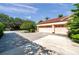 Ample three-car garage and expansive driveway, perfect for parking and outdoor activities, enhanced by mature trees at 1008 Royal Birkdale Dr, Tarpon Springs, FL 34688