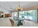 Cozy dining space on lanai, featuring a glass table, wicker chairs, and pool views through sliding glass doors at 1008 Royal Birkdale Dr, Tarpon Springs, FL 34688