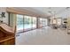Bright lanai with tile flooring, large sliding glass doors overlooking the swimming pool, and outdoor seating at 1008 Royal Birkdale Dr, Tarpon Springs, FL 34688