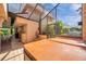Enclosed patio featuring a hot tub, tiled floor, and partial screening for outdoor living and entertaining at 1008 Royal Birkdale Dr, Tarpon Springs, FL 34688