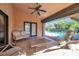 Relaxing outdoor patio area with cozy seating, ceiling fan, and a clear view of the inviting backyard swimming pool at 1008 Royal Birkdale Dr, Tarpon Springs, FL 34688