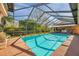 Inviting pool with a screened enclosure, beautiful landscaping, and ample lounging areas for relaxation at 1008 Royal Birkdale Dr, Tarpon Springs, FL 34688