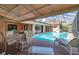 Sparkling pool with lounge chairs and outdoor dining under a screened enclosure, perfect for entertaining at 1008 Royal Birkdale Dr, Tarpon Springs, FL 34688