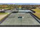 Aerial view of multiple well-maintained tennis courts near a pond and lush greenery at 1008 Royal Birkdale Dr, Tarpon Springs, FL 34688