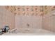 Close-up of a bathtub with tile surround and floral wallpaper above at 1008 Royal Birkdale Dr, Tarpon Springs, FL 34688