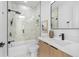 Modern bathroom with marble tile, a glass shower door, wood vanity, and black fixtures at 101 W Warren Ave # 1, Tampa, FL 33602