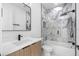Modern bathroom with a walk-in shower, marble-like tiles, and sleek black fixtures over white countertop vanity at 101 W Warren Ave # 1, Tampa, FL 33602