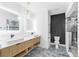 Modern bathroom featuring a double sink vanity, blue marble tile, accent wall, and glass enclosed shower at 101 W Warren Ave # 1, Tampa, FL 33602