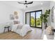 Cozy bedroom featuring a sliding glass door to a balcony with natural light and a ceiling fan at 101 W Warren Ave # 1, Tampa, FL 33602