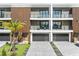 A modern townhome complex with gray garages, balconies, wood accents, and a palm tree in front at 101 W Warren Ave # 1, Tampa, FL 33602