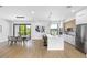 Bright, open kitchen and dining area featuring a large island, stainless steel appliances, and stylish pendant lighting at 101 W Warren Ave # 1, Tampa, FL 33602