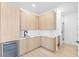 Modern laundry room featuring light wood cabinetry, white countertops, and sleek fixtures, adjacent to a glass-enclosed shower at 101 W Warren Ave # 1, Tampa, FL 33602