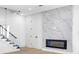 Bright living room with a modern fireplace, a glass staircase railing, and clean white walls at 101 W Warren Ave # 1, Tampa, FL 33602