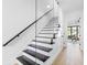 Modern staircase featuring sleek design, glass railings, and hardwood floors at 101 W Warren Ave # 1, Tampa, FL 33602