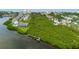 Aerial shot of waterfront homes nestled amongst lush trees, featuring a pier and water access at 11722 Currie Ln # G1, Largo, FL 33774