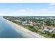 Breathtaking aerial showcases sandy beachfront near beautiful homes and clear blue water at 11722 Currie Ln # G1, Largo, FL 33774