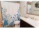 Bathroom featuring a walk-in shower, modern vanity with sink, and stylish mirror with shells at 11722 Currie Ln # G1, Largo, FL 33774