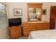 Bedroom features a dresser with mirror and a TV, offering convenience and entertainment at 11722 Currie Ln # G1, Largo, FL 33774