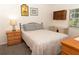 Bedroom with a comfortable bed, nightstand with lamp, and a desk, creating a relaxing and functional area at 11722 Currie Ln # G1, Largo, FL 33774
