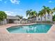 Community pool and seating area with plenty of lounge chairs and palm trees at 11722 Currie Ln # G1, Largo, FL 33774