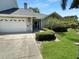 Home exterior with two-car garage, walkway to front door and lush green lawn at 11722 Currie Ln # G1, Largo, FL 33774