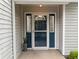 The home has a beautiful blue front door, side windows, and modern light fixture at 11722 Currie Ln # G1, Largo, FL 33774