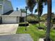 Well-maintained front yard and entrance to home with mature palm trees and green grass at 11722 Currie Ln # G1, Largo, FL 33774