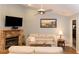 Cozy living room featuring a stone fireplace and a large flatscreen television at 11722 Currie Ln # G1, Largo, FL 33774