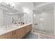 Luxurious bathroom featuring a dual sink vanity and a spacious glass-enclosed shower with a rainfall showerhead at 125 Island Way # 402, Clearwater Beach, FL 33767