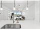 Bright, open-concept kitchen featuring a stainless sink, sleek white countertops, and modern pendant lighting at 125 Island Way # 402, Clearwater Beach, FL 33767