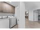 Well-equipped laundry room with modern washer and dryer units and overhead cabinets at 125 Island Way # 402, Clearwater Beach, FL 33767
