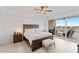 Bright main bedroom with ceiling fan and sliding glass doors to private balcony overlooking the city at 125 Island Way # 402, Clearwater Beach, FL 33767