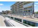 Waterfront deck area with a pool, lounge chairs, tables, and BBQ grill for outdoor living and entertaining at 125 Island Way # 402, Clearwater Beach, FL 33767
