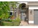 Charming front entrance with a decorative wreath, arched window, and lush landscaping at 12956 Royal George Ave, Odessa, FL 33556