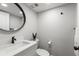 Modern half-bathroom with round mirror, sleek vanity, and stylish fixtures at 1324 Pasadena S Ave # 204, South Pasadena, FL 33707