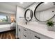 Modern bathroom featuring double round mirrors, sleek white cabinetry, and a stylish black faucet at 1324 Pasadena S Ave # 204, South Pasadena, FL 33707
