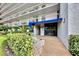 Building entrance with lush landscaping, brick walkway, and blue awning at 1324 Pasadena S Ave # 204, South Pasadena, FL 33707