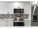 Modern kitchen features stainless steel appliances, white cabinetry and black hardware at 1324 Pasadena S Ave # 204, South Pasadena, FL 33707